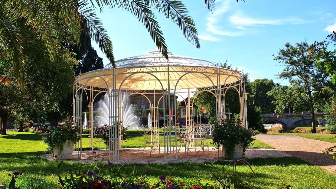 Pavillon Toskana in pulvebeschichteter Sonderfarbe mit Sonnensegel und Messingkugel im Park