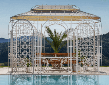 Pavillon Verona in pulverbeschichteter Sonderfarbe weiss mit Sonnensegel hinter einem Pool