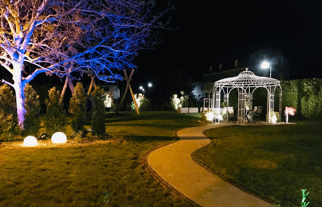 Pavillon Florenz pulverbeschichtet anthrazit mit Messingkugel in einem Garten bei Nacht beleuchtet