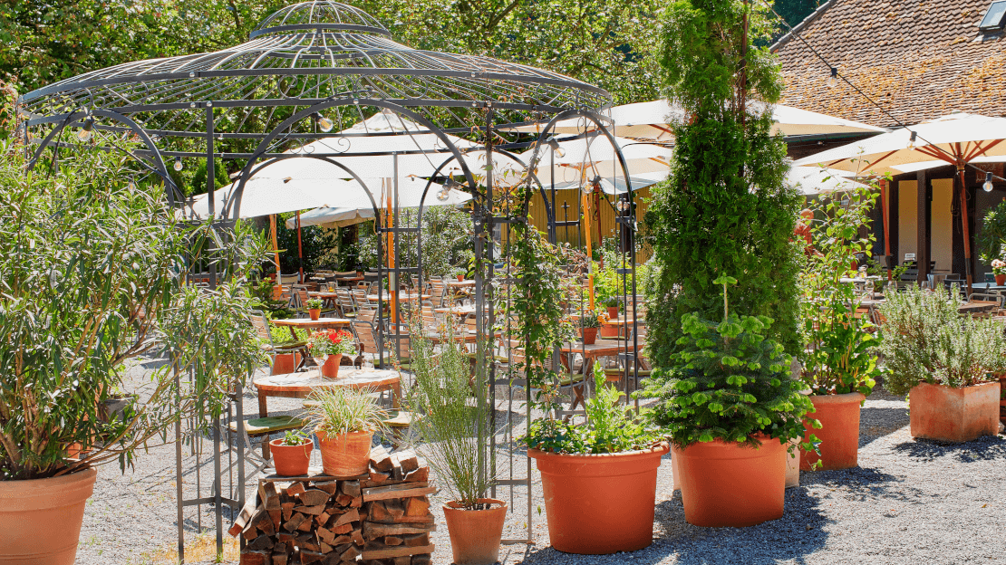 Pavillon Florenz pulverbeschichtet anthrazit mit Tisch und Stuehlen im Garten eines Restaurants