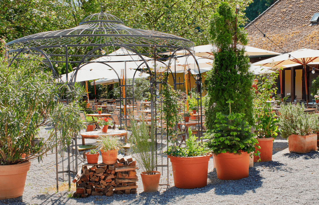 Pavillon Florenz pulverbeschichtet anthrazit mit Tisch und Stuehlen im Garten eines Restaurants