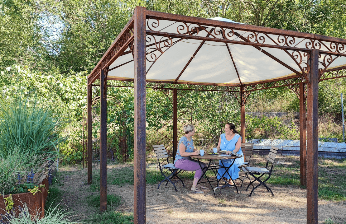 Gemütliche Sitzecke unter einem Metallpavillon